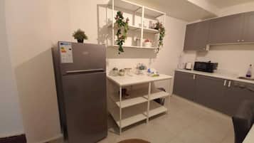 Een koelkast, een microgolfoven, een kookplaat, een waterkoker