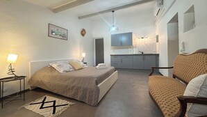 A bedroom with a bed, bedside table, lamp, and a patterned rug. - House with pool in the Luberon for 6 people (Saint-Saturnin-lès-Apt)