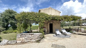 A stone structure with a doorway, surrounded by a gravel patio and outdoor seating. - House with pool in the Luberon for 6 people (Saint-Saturnin-lès-Apt)