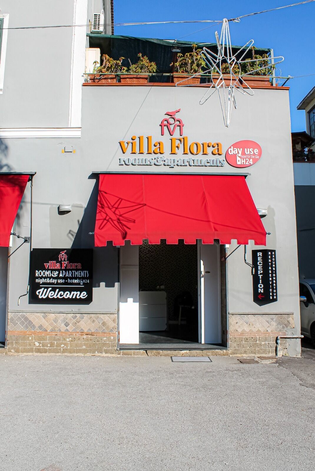 The exterior of Villa Flora, a hotel with a red awning and a sign indicating it is a day-use hotel.
