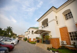A row of two-story houses with a paved driveway, a covered entrance, and a small balcony on the second floor. - Prosbel Hotel (Abuja)