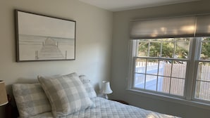A bedroom with a bed, a window with blinds, a lamp, and a framed picture on the wall. -  Charming Cape Cod home, minutes to Nantucket Sound (Harwich)