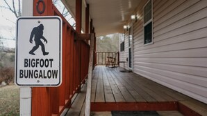 A porch with a sign indicating a Bigfoot Bungalow. - Book now to get your free ticket to Dollywood, Anakeesta, and other venues! (Sevierville)
