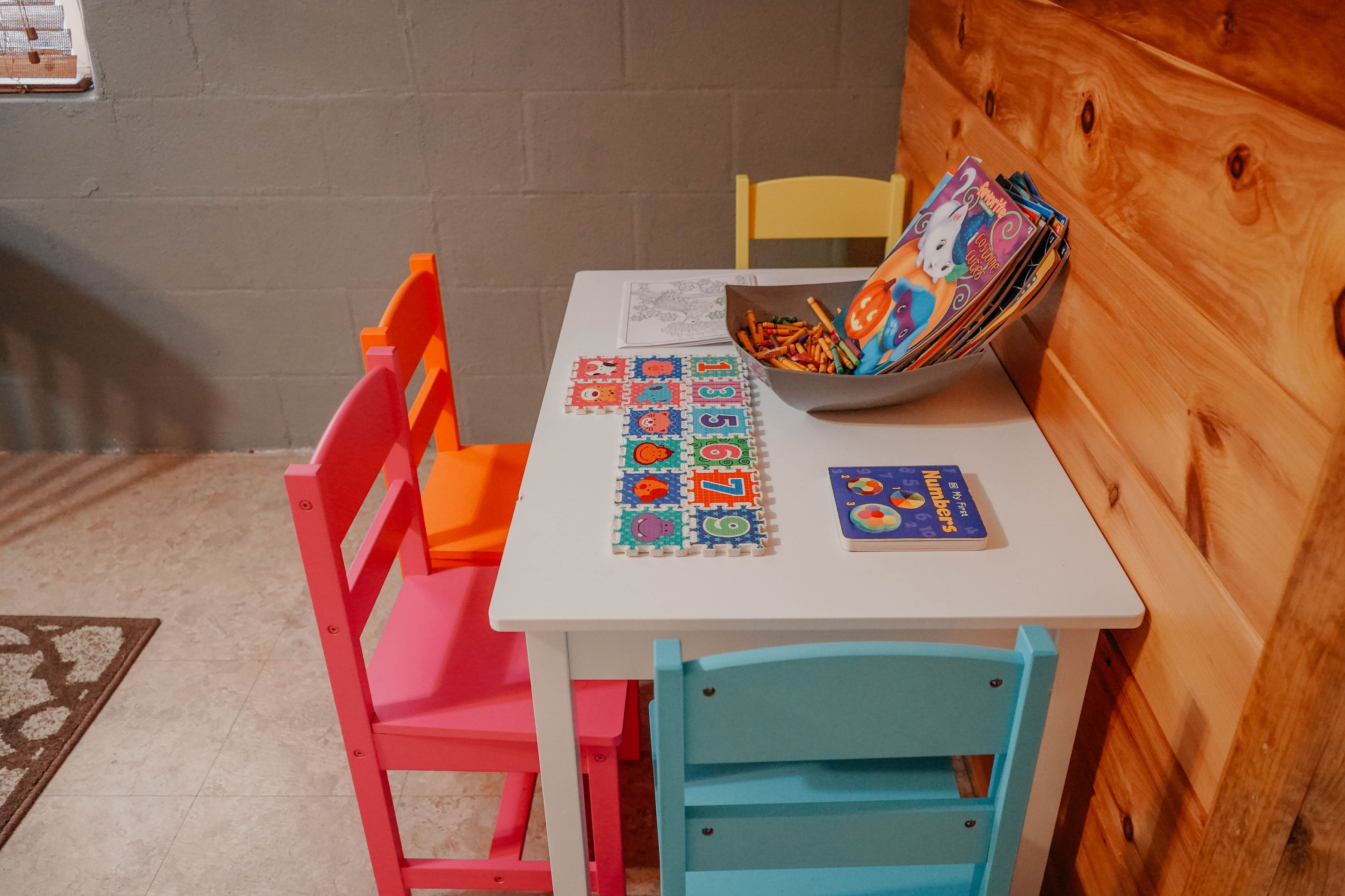 A small table with educational materials, a chair, and a wooden cabinet.