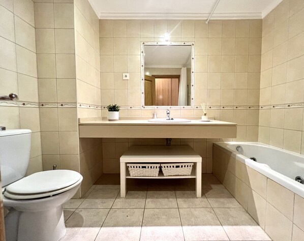 Une salle de bain avec des toilettes, un lavabo et une baignoire.