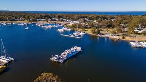 An aerial view of a marina with multiple boats docked, surrounded by residential buildings and greenery.