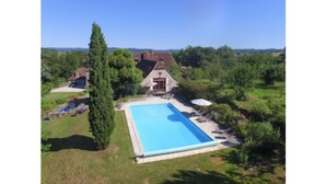 A large rectangular swimming pool surrounded by a lawn, with a stone building in the background. - 6 bedroom manor house in large property with pool and garden, games room (Curemonte)