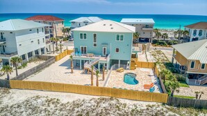 A beachfront property with a swimming pool, multiple balconies, and a view of the ocean. - Beautiful 6 BR Gulf View Home | Private Pool | Pet Friendly | Event Friendly (Pensacola Beach)