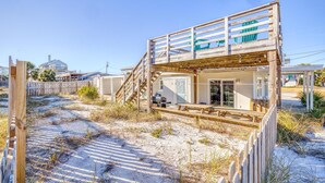 Una propiedad frente a la playa con una terraza de madera, un área de estar techada al aire libre y vistas al océano.
