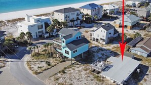 Vista aérea de una zona residencial costera con casas, una playa y una carretera.