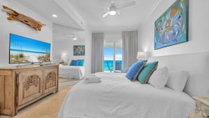 A spacious bedroom with a large bed, a wooden dresser, a television, and a balcony with a view of the ocean. - Adagio B-203 Beach Front 4/3 - Beautiful Unit with Beautiful Views! (Santa Rosa Beach)