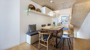 Un espace repas comprenant une table en bois, des chaises et un banc.