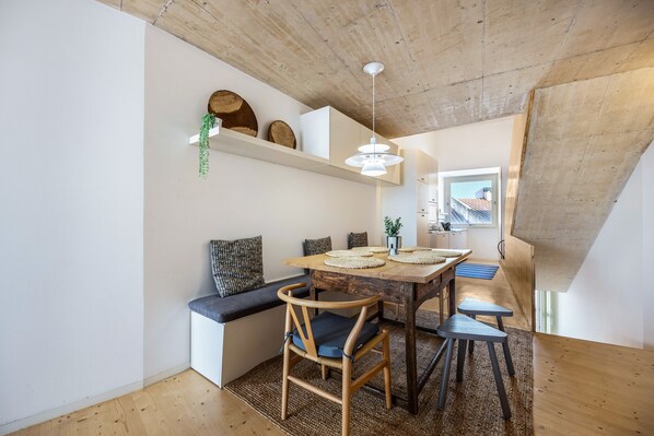 A dining area with a wooden table, chairs, and a bench.