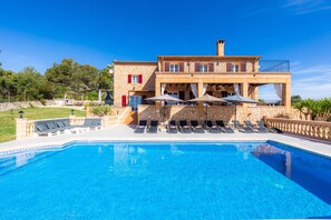A stone building with a swimming pool, outdoor seating, and a view of the surrounding landscape. - Villa 'Maria' with Mountain View, Wi-Fi and Air Conditioning (Manacor)