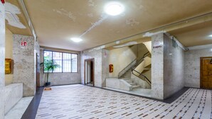 A spacious lobby with a patterned floor, a staircase, and a large window. - Piazza Municipio Blue Apartment by Wonderful Italy (Naples)