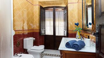 A bathroom with a toilet, sink, and mirror.