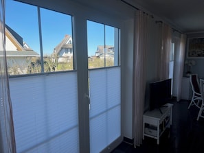 Enjoy a peaceful retreat with a sliding glass door leading to an outdoor area, a comfortable workspace, and a flat-screen TV.