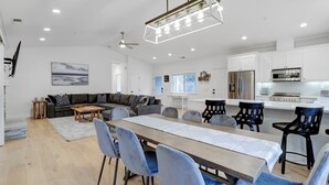 Una cocina moderna con armarios blancos, un refrigerador de acero inoxidable y un microondas.