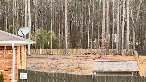 A residential area with a wooden fence, a brick house, and a satellite dish. - Nice family home (Hiram)