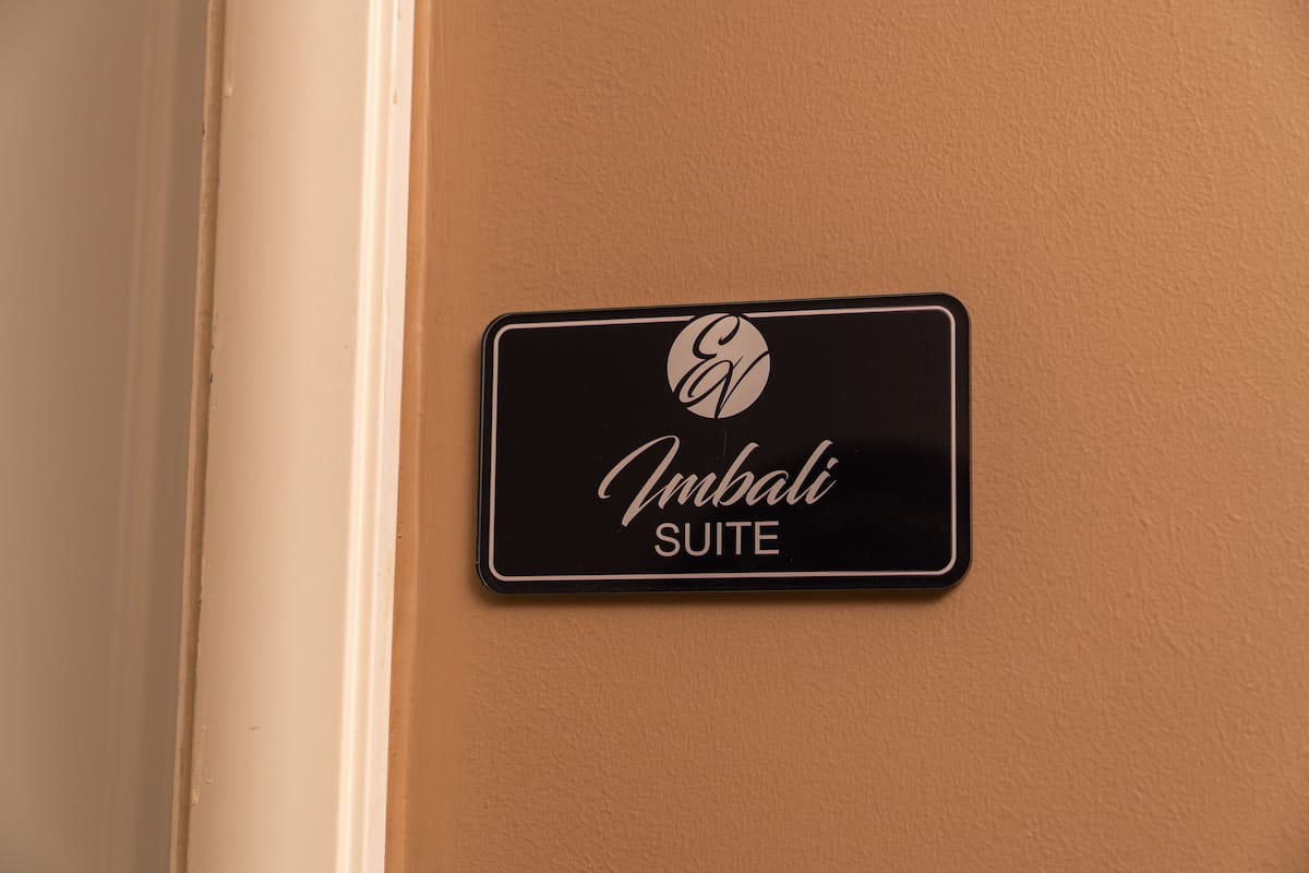 Een bordje voor de 'Embali Suite' met een logo en tekst.