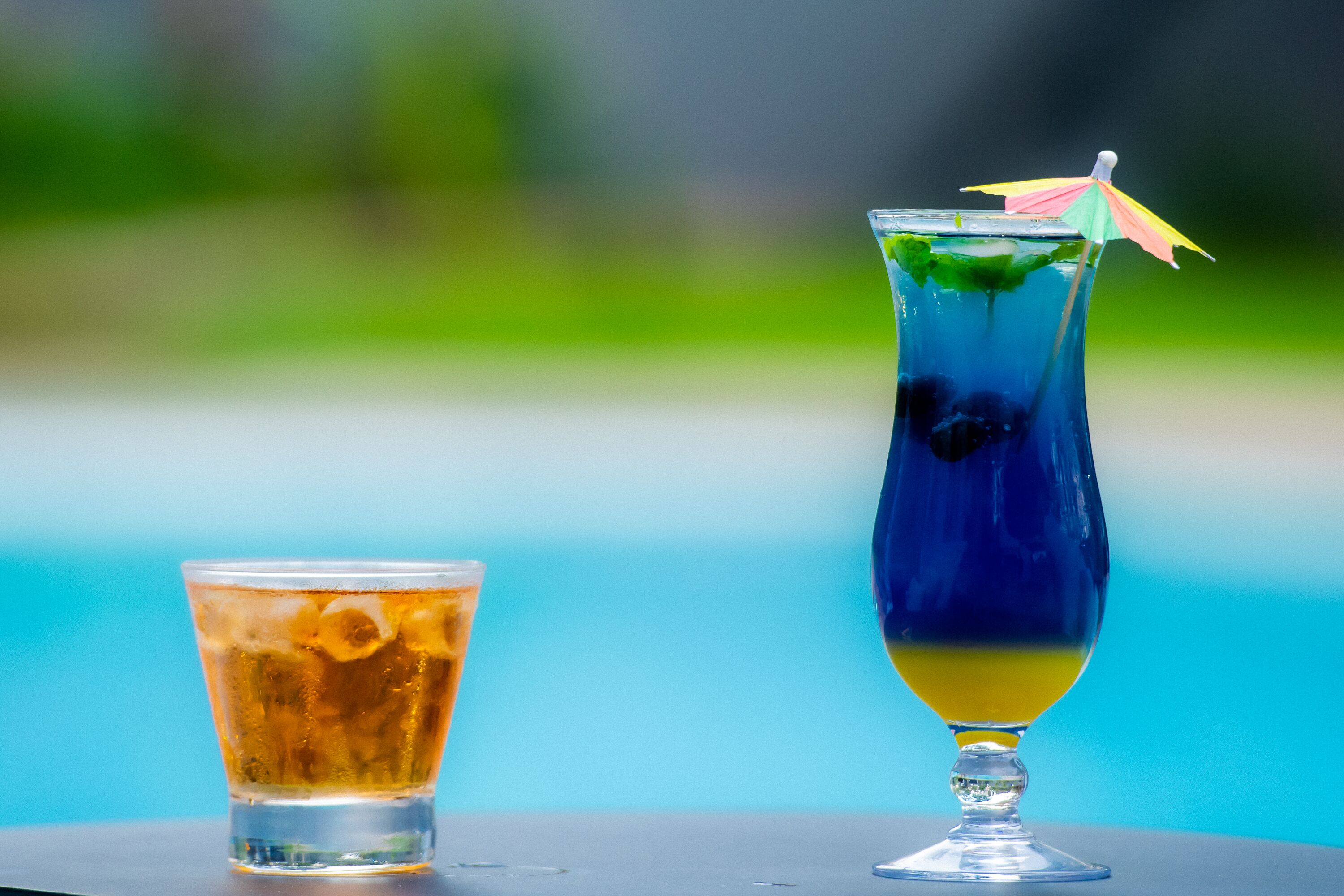 Two drinks on a table with a blurred blue background.