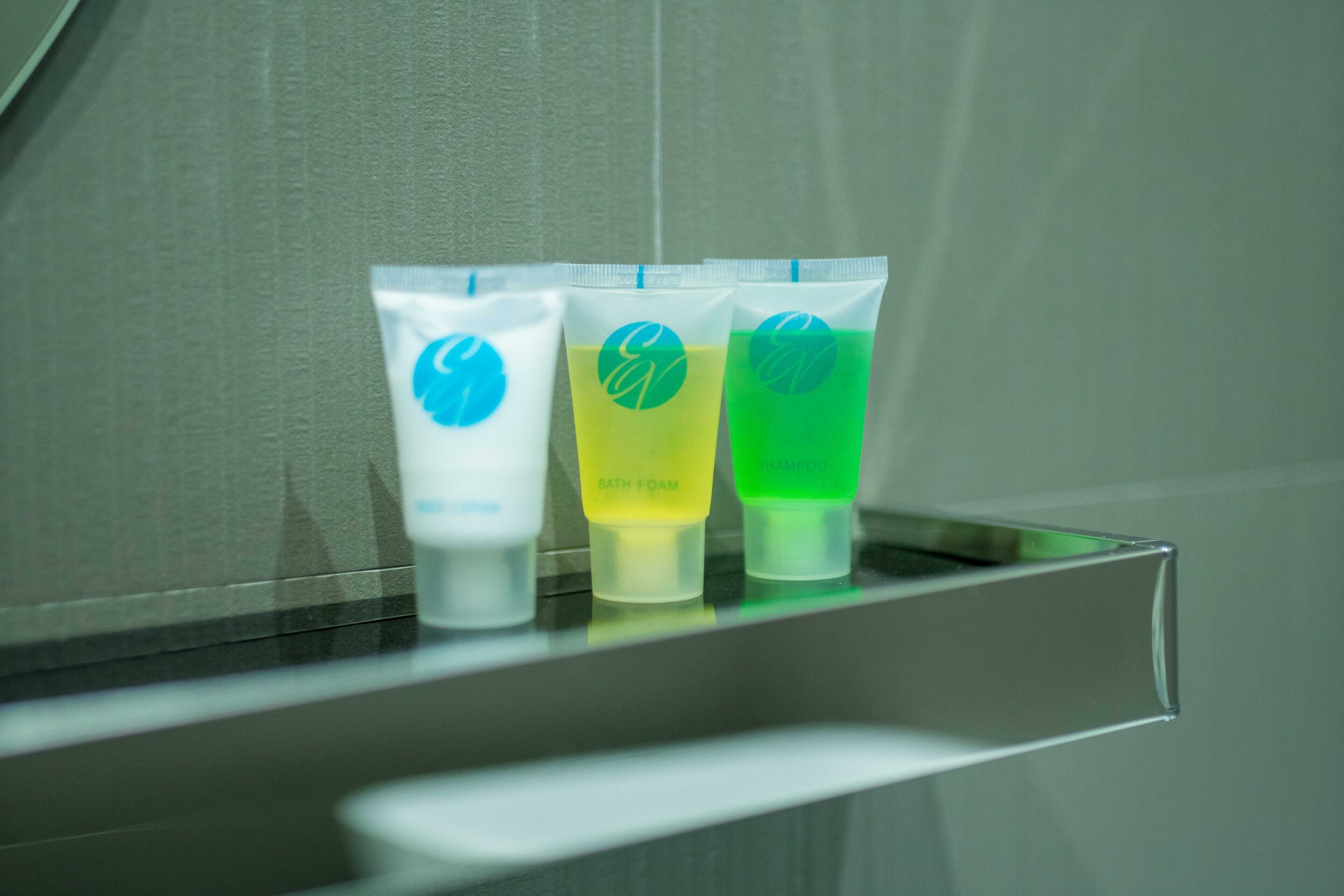 Three toiletry tubes on a bathroom counter.