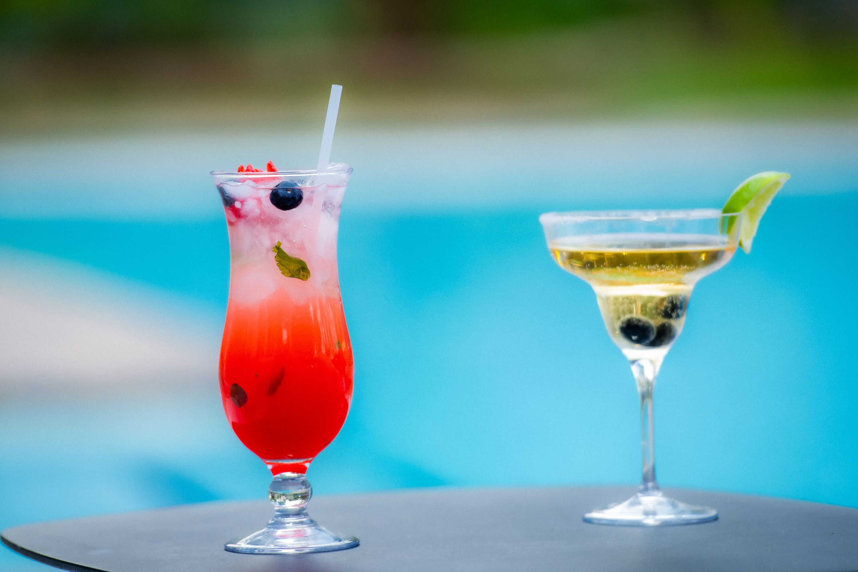 Due cocktail su un tavolo vicino a una piscina.