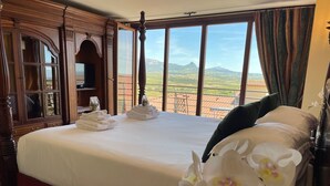 Ein Hotelzimmer mit einem großen Bett, Blick auf die Landschaft und einem Holzschrank.