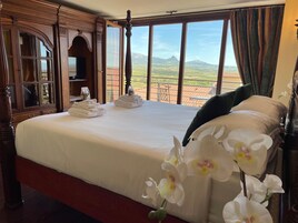 Habitación de hotel con una cama grande, vistas al campo y un armario de madera.