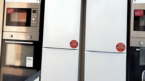 A kitchen with a microwave, oven, and refrigerator. There are signs indicating a registration process for appliances. - Kunda House Bournbrook (Birmingham)