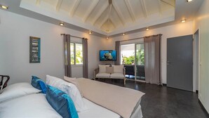 A modern bedroom with a large bed, a sofa, and a TV. - Beautiful Carmen Luxury villa (Vitet)
