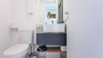 A modern bathroom with a toilet, sink, and towel rack.