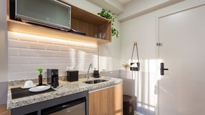 A modern kitchen with granite countertops, a built-in dishwasher, a microwave, and wooden cabinets.