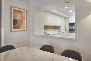 A modern kitchen with white cabinets, a stainless steel sink, and a wooden countertop. - Olabar I | The Rentals Collection (San Sebastián)