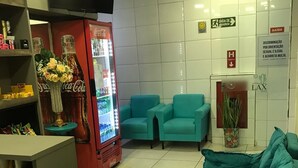 Un vestíbul amb sofàs color aquamarina, un nevera de Coca-Cola, una televisió i un senyal que indica una zona per fumar.