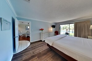 Relax in this serene space with a large bed against a window offering a view of the outdoors.