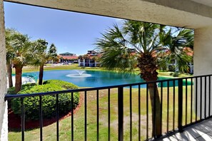 Enjoy a serene view from this balcony overlooking a tranquil outdoor space with a central water feature and lush greenery.
