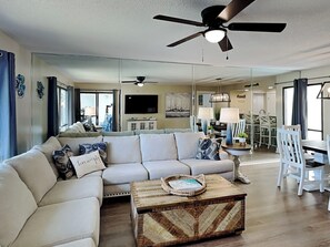 Relax in this stylish living room with a large sofa, coffee table, and dining area.