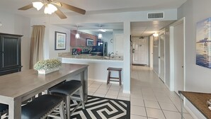 Una cocina moderna con una isla central, iluminación colgante y un ventilador de techo.