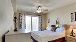 Une chambre d’hôtel équipée d’un lit, d’une table de chevet, d’une lampe et d’un ventilateur de plafond.