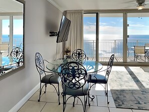 Enjoy meals in this dining area with a round table and four chairs, offering a view of the sea.