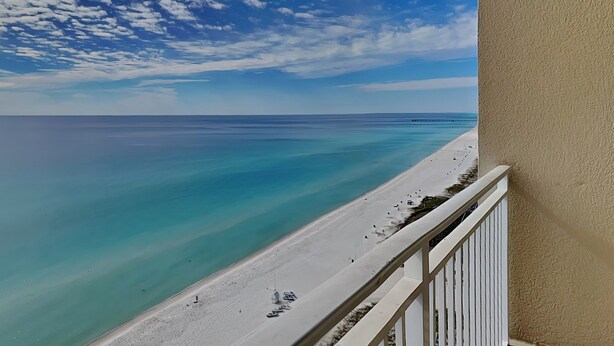 Un balcon avec vue sur une plage et l’océan.