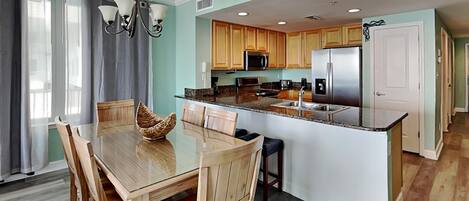 A modern kitchen with wooden cabinets, a stainless steel refrigerator, and a central island.
