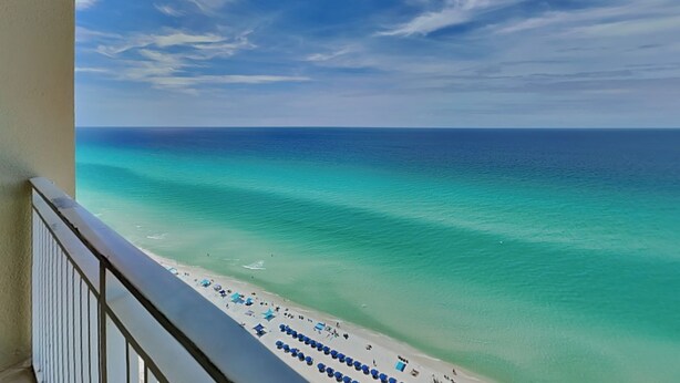 Ein Balkon mit Blick auf Strand und Meer.