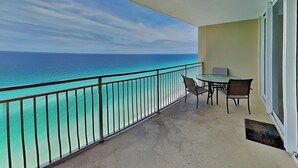 Ein Balkon mit Meerblick, einem Tisch und Stühlen sowie einer Tür.