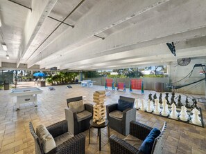 Relax and play in our outdoor recreational area, featuring a ping pong table, foosball table, chess set, lounge chairs, and a hammock.