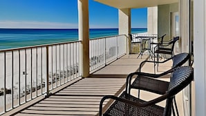 A balcony with a view of the ocean, featuring a table and chairs. - Long Beach I #503 | Balcony Views! (Panama City Beach)