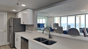 Een moderne keuken met een vaatwasser, dubbele spoelbak en witte kasten.