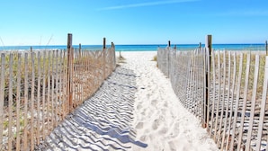 A sandy beach path flanked by wooden fences leading to the ocean. - Long Beach I #900 | Updated Interior! (Panama City Beach)