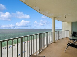 A balcony with a view of the beach and ocean.